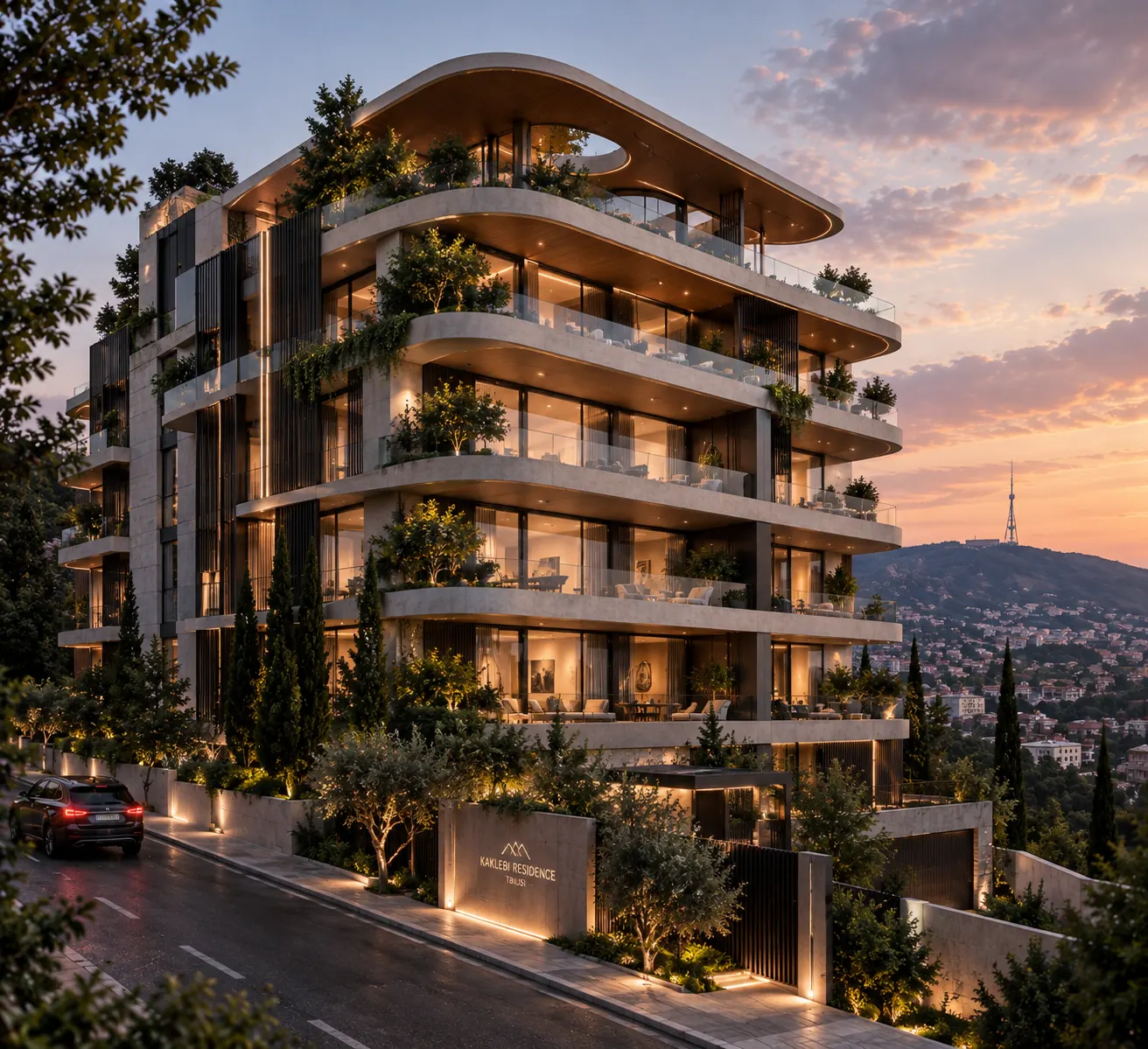 Kaklebi Residence at dusk: curved stone terraces with planting, the gated entrance on the street and Tbilisi with the Mtatsminda TV tower behind